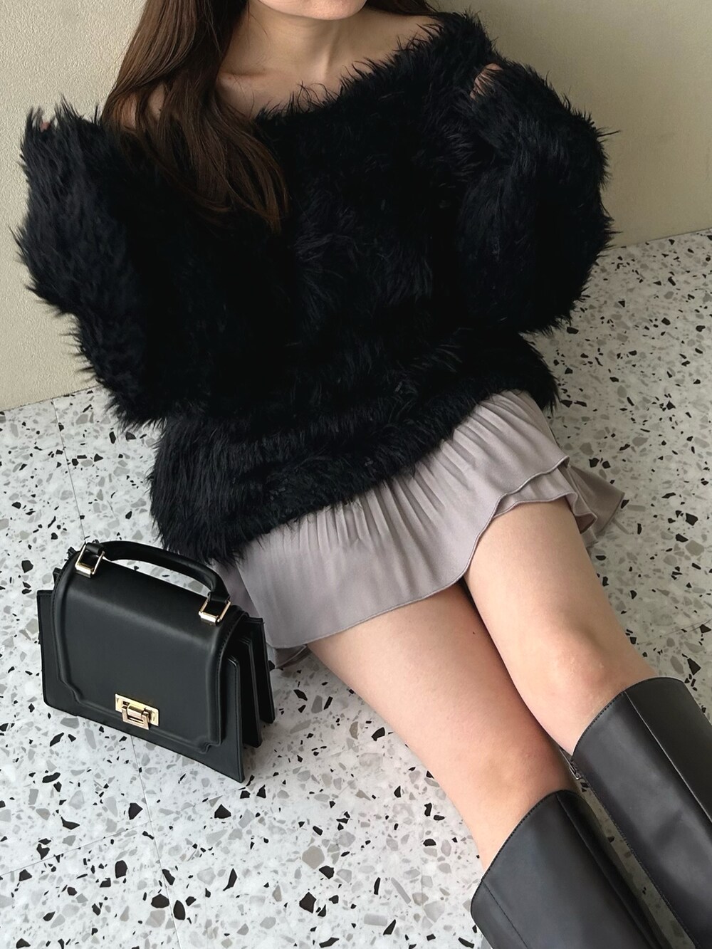 ピンク系のスカート、ブラック系のニット/セーター、ブラウン系のブーツを着用したレディースの冬コーディネートの5枚目の写真