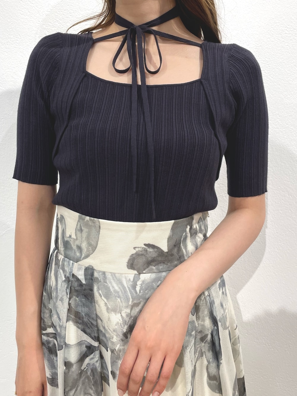 グレー系のニット/セーター、ホワイト系のスカート、ホワイト系のサンダルを着用したレディースの春コーディネートの4枚目の写真