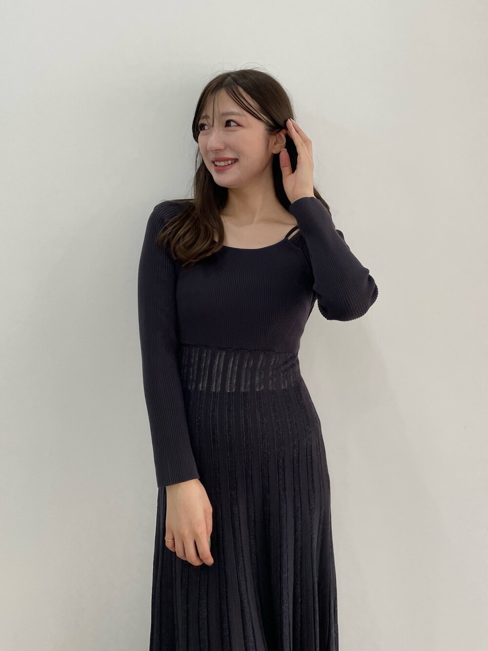 グレー系のワンピース、ホワイト系のトレンチコートを着用したレディースの冬コーディネートの3枚目の写真