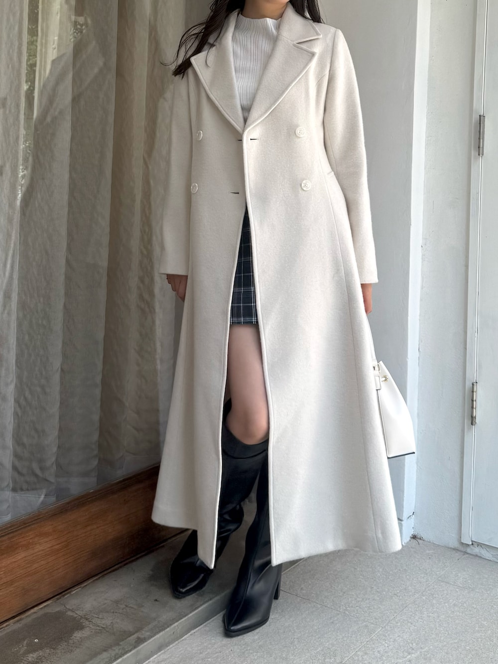 グリーン系のスカート、ホワイト系のニット/セーター、ホワイト系のショルダーバッグを着用したレディースの秋コーディネートの4枚目の写真