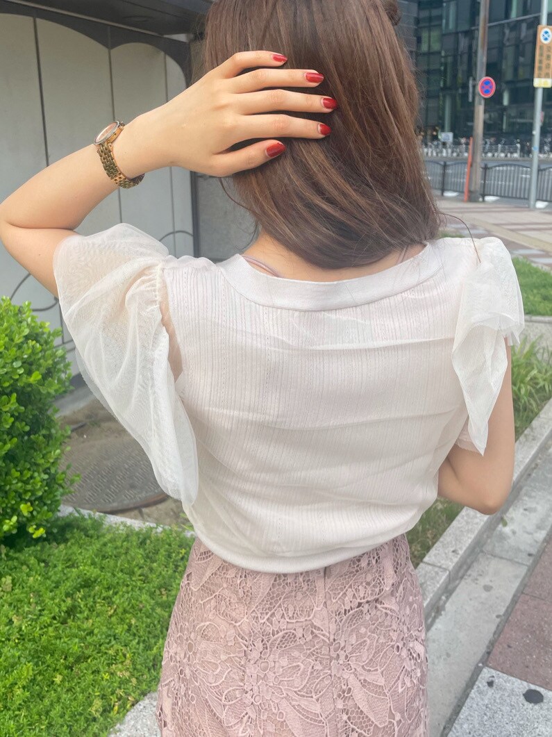 ベージュ系のスカート、ホワイト系のニット/セーターを着用したレディースの春コーディネートの5枚目の写真