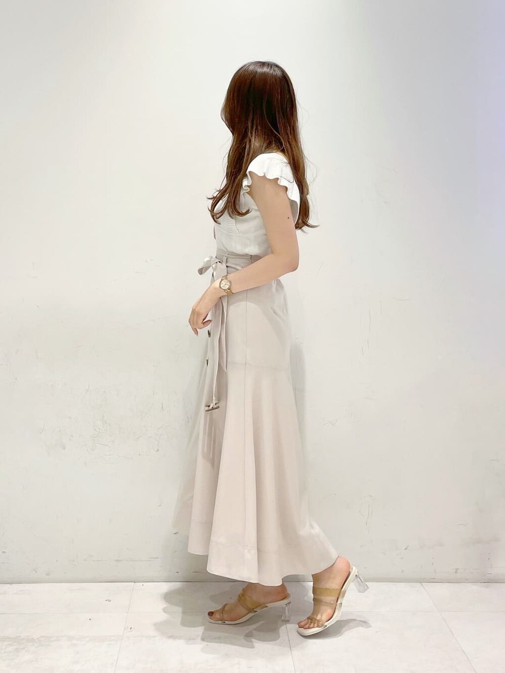 ベージュ系のサンダル、ホワイト系のニット/セーター、ホワイト系のスカートを着用したレディースの春コーディネートの2枚目の写真