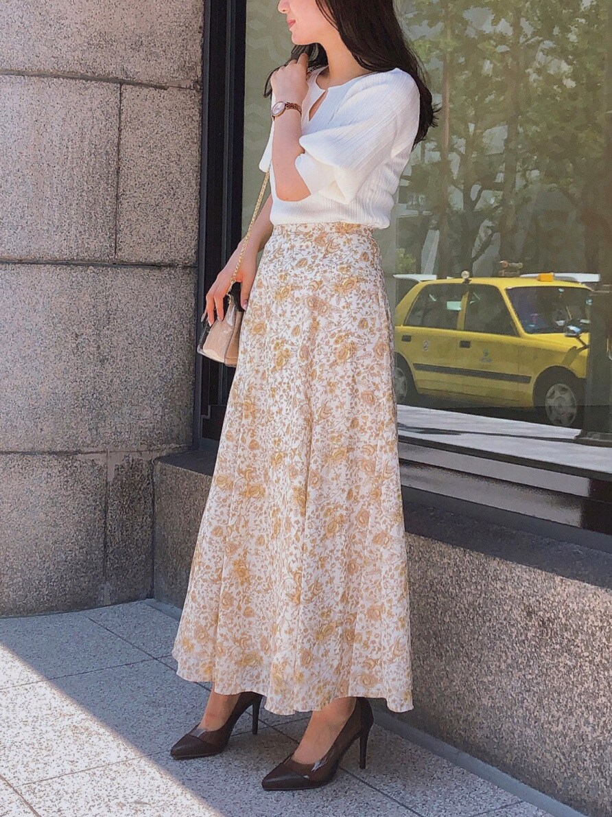 ベージュ系のスカート、ブラウン系のパンプスを着用したレディースの夏コーディネートの2枚目の写真