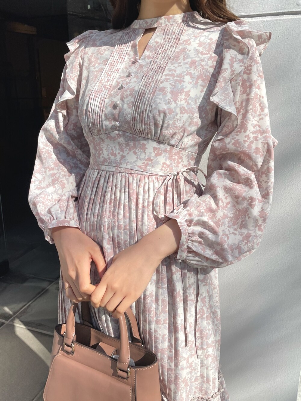 ブラック系のブーツ、ブラウン系のハンドバッグ、ベージュ系のワンピースを着用したレディースの春コーディネートの3枚目の写真