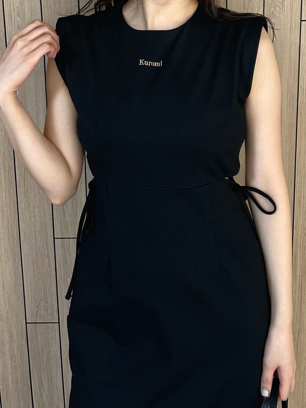 ブラック系のショルダーバッグ、ベージュ系のサンダル、ブラック系のワンピースを着用したレディースの春コーディネートの5枚目の写真