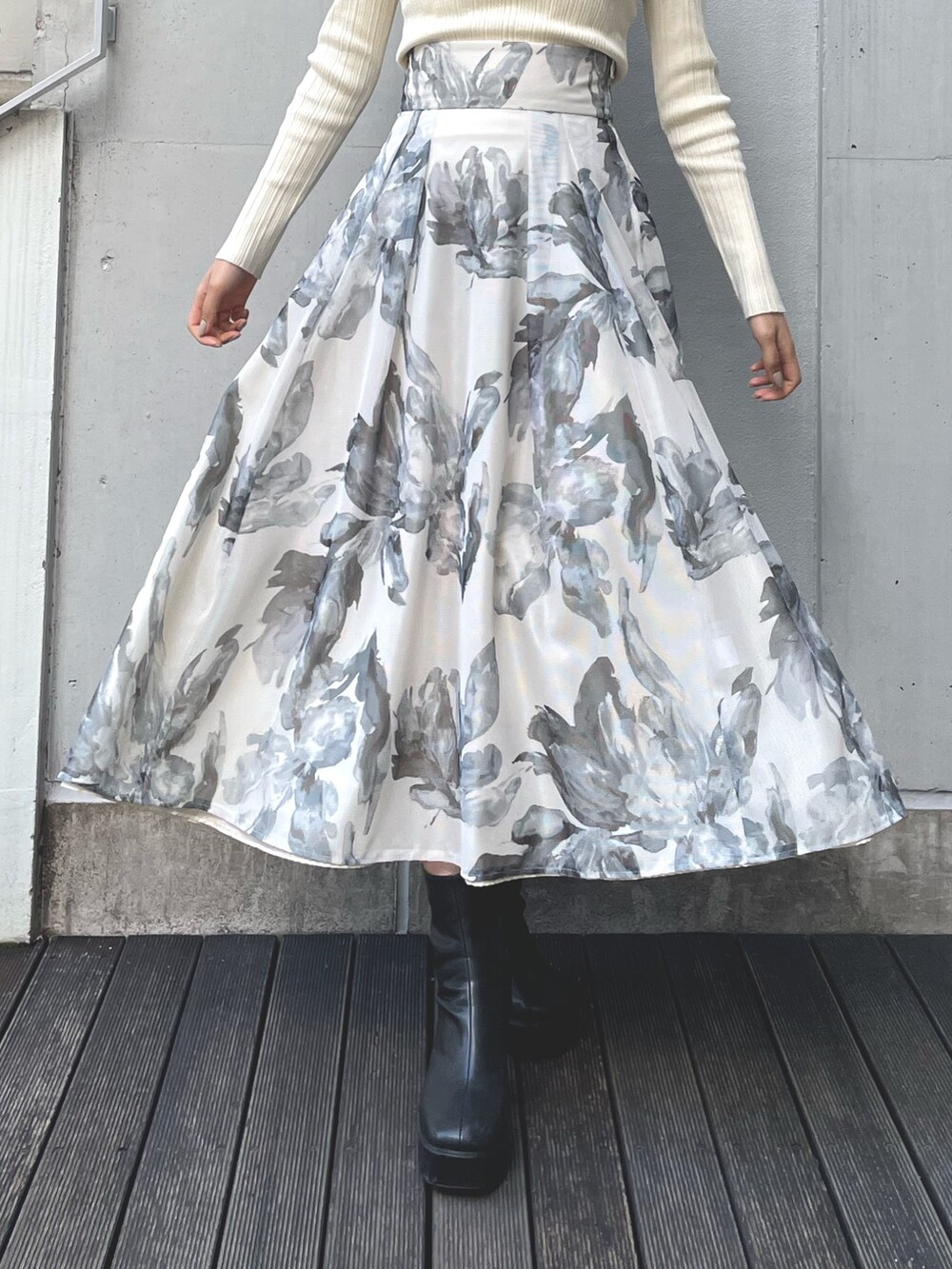 イエロー系のニット/セーター、ホワイト系のスカートを着用したレディースの冬コーディネートの5枚目の写真