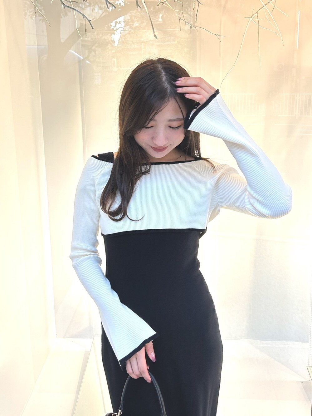 ブラック系のワンピース、ブラック系のショルダーバッグ、ブラック系のブーツを着用したレディースの秋コーディネートの6枚目の写真