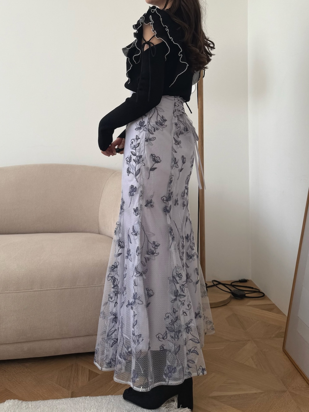 ブラック系のニット/セーター、パープル系のスカート、ブラック系のブーツを着用したレディースの秋コーディネートの4枚目の写真