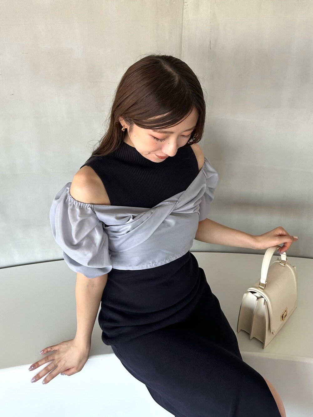 ブルー系のワンピース、ホワイト系のハンドバッグ、ホワイト系のブーツを着用したレディースの冬コーディネートの8枚目の写真