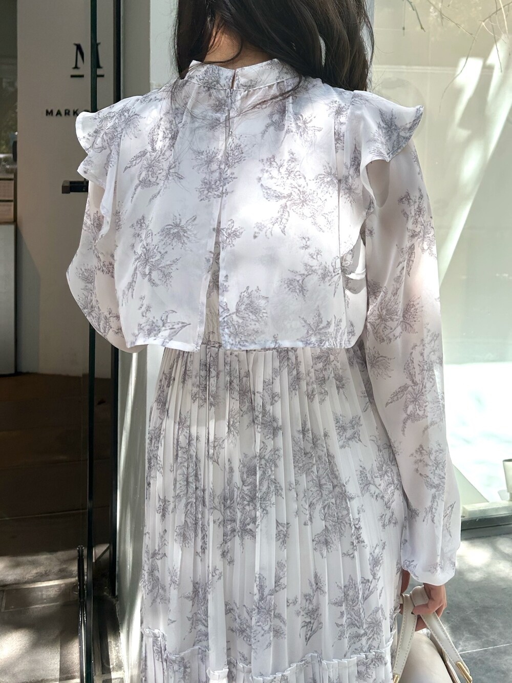 ホワイト系のハンドバッグ、ピンク系のワンピースを着用したレディースの秋コーディネートの5枚目の写真