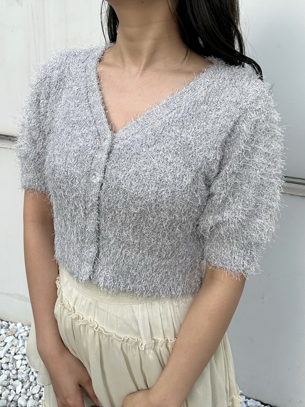 ホワイト系のカーディガン/ボレロ、シルバー系のハンドバッグ、ホワイト系のスカートを着用したレディースの冬コーディネートの3枚目の写真