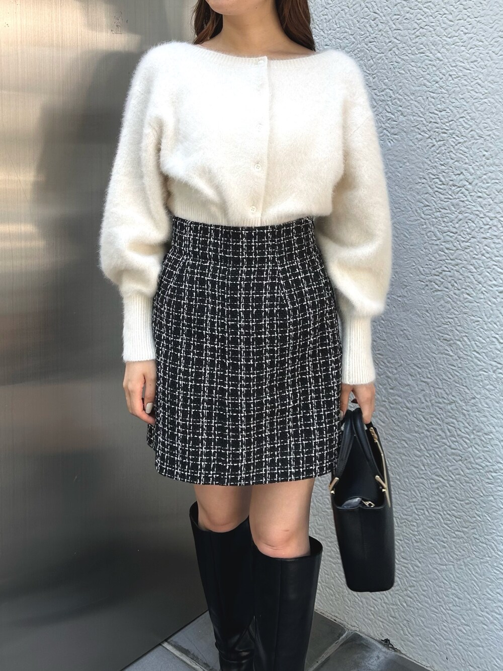 ホワイト系のカーディガン/ボレロ、ブラック系のスカート、ブラック系のブーツを着用したレディースの秋コーディネートの4枚目の写真