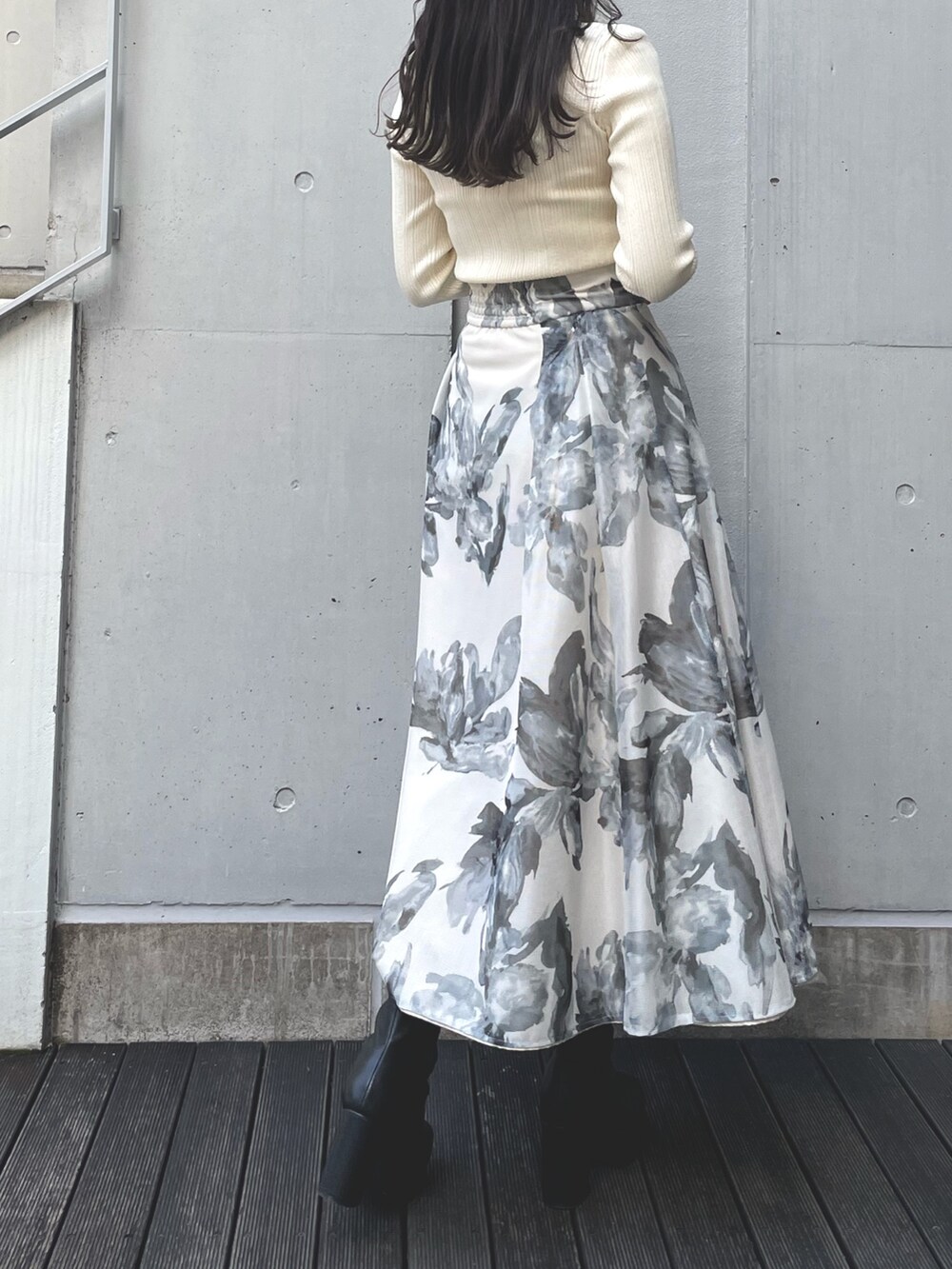 イエロー系のニット/セーター、ホワイト系のスカートを着用したレディースの冬コーディネートの3枚目の写真