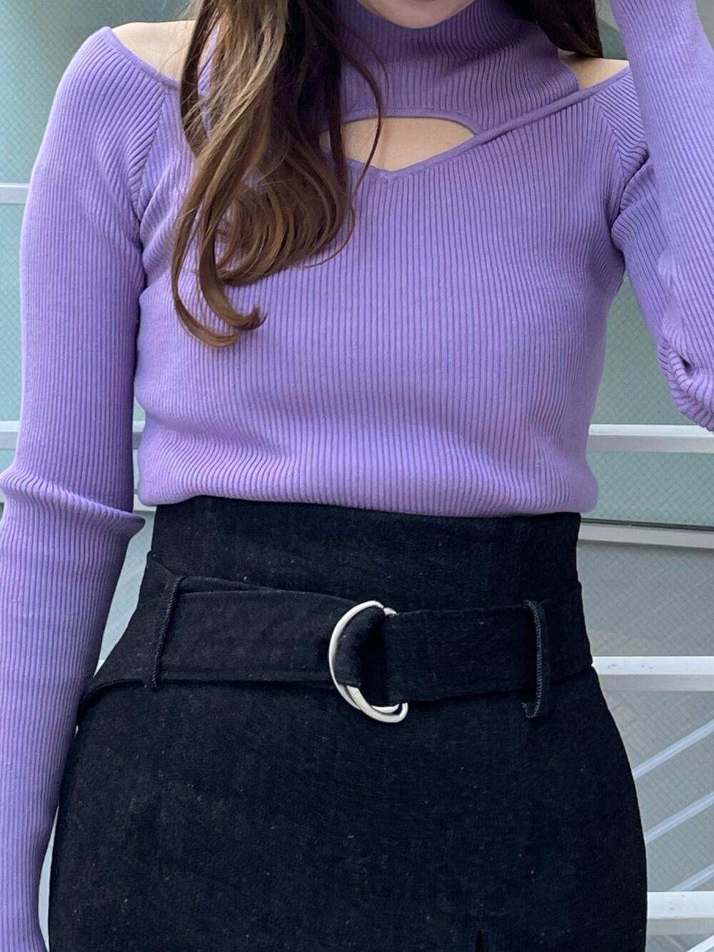 パープル系のニット/セーター、ブラック系のハンドバッグ、ブラック系のスカートを着用したレディースの冬コーディネートの3枚目の写真