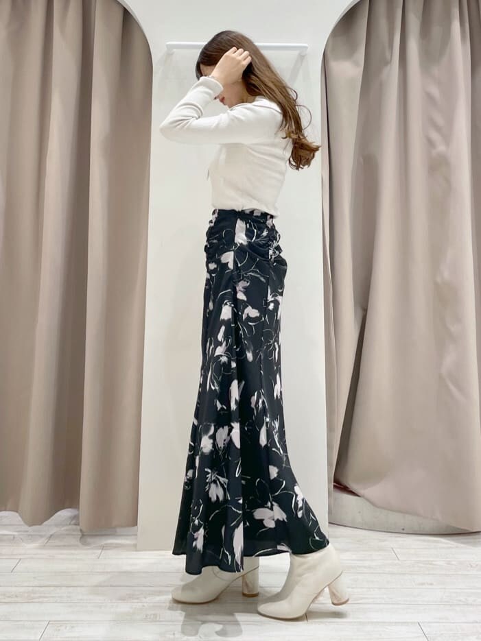 ブラック系のその他シューズ、ホワイト系のニット/セーター、ブラック系のスカートを着用したレディースの秋コーディネートの2枚目の写真