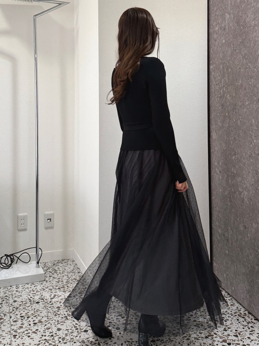 ブラック系のワンピース、ブラック系のブーツを着用したレディースの秋コーディネートの3枚目の写真