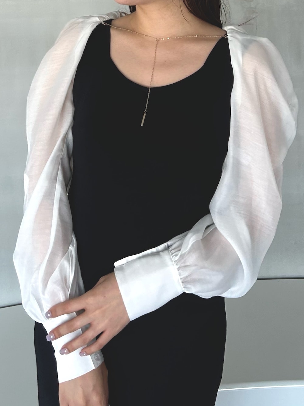 ブラック系のワンピース、ホワイト系のサンダルを着用したレディースの冬コーディネートの4枚目の写真