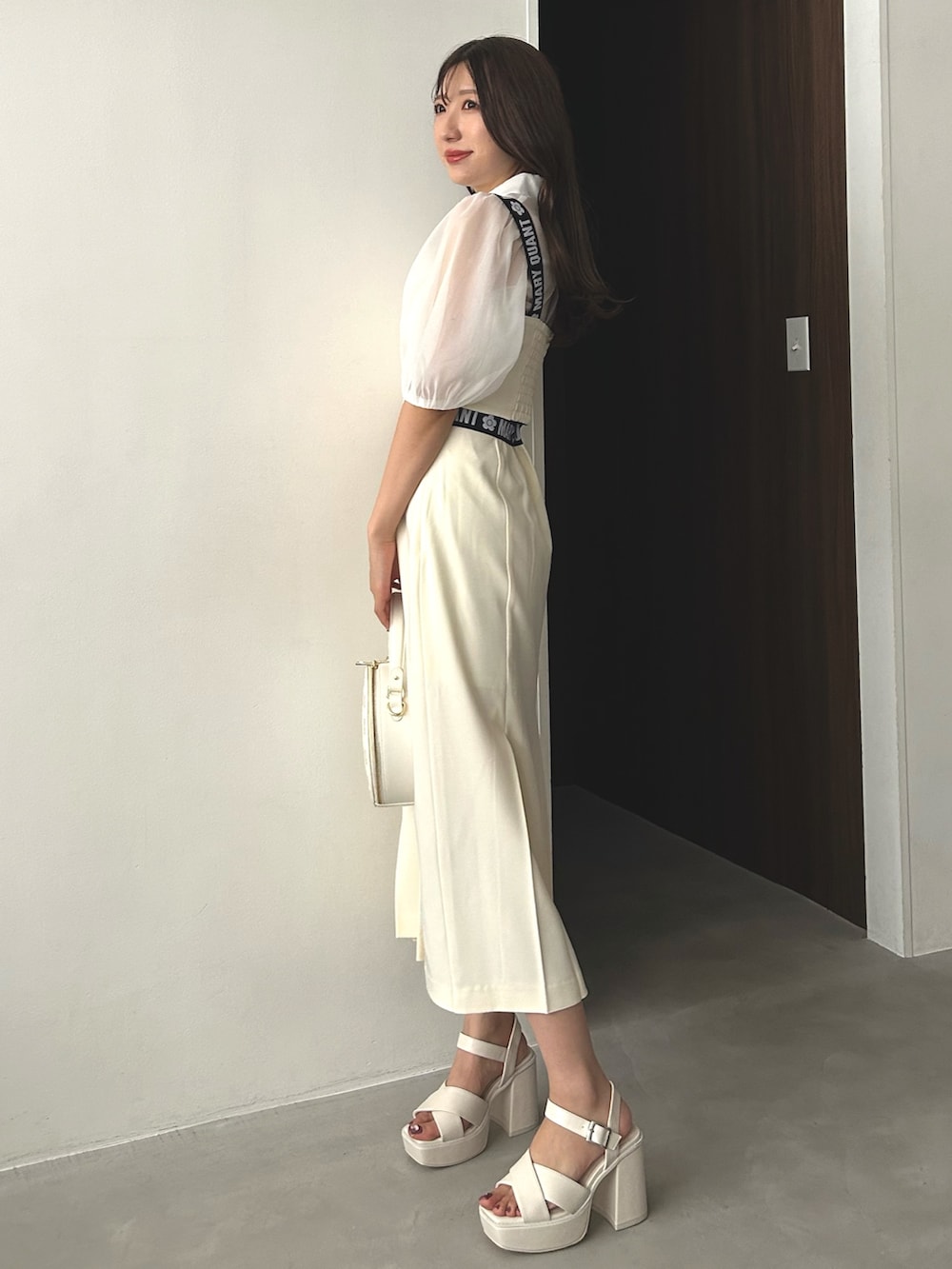 ホワイト系のシャツ/ブラウス、ホワイト系のスカート、ホワイト系のショルダーバッグを着用したレディースの冬コーディネートの3枚目の写真