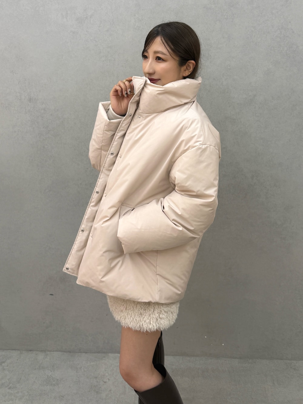 ピンク系のダウンジャケット/コート、ホワイト系のスカート、ブラウン系のブーツを着用したレディースの秋コーディネートの6枚目の写真