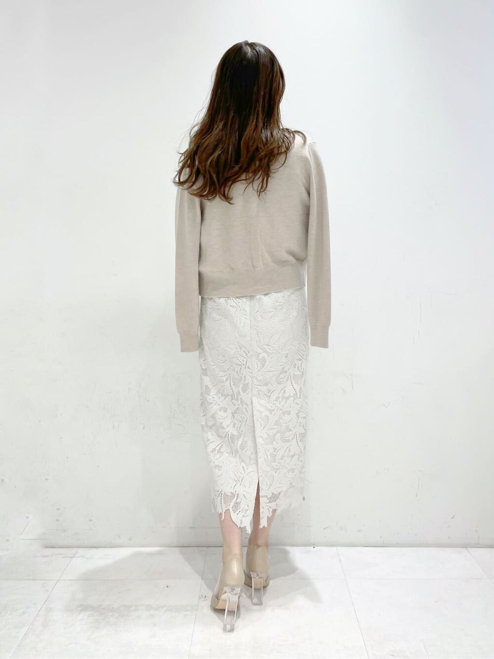 ベージュ系のパンプス、ベージュ系のニット/セーター、ホワイト系のスカートを着用したレディースの冬コーディネートの2枚目の写真