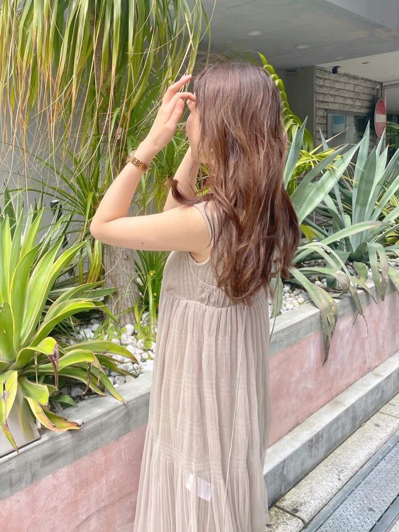 ベージュ系のワンピース、ホワイト系のサンダル、ゴールド系のイヤリングを着用したレディースの春コーディネートの4枚目の写真