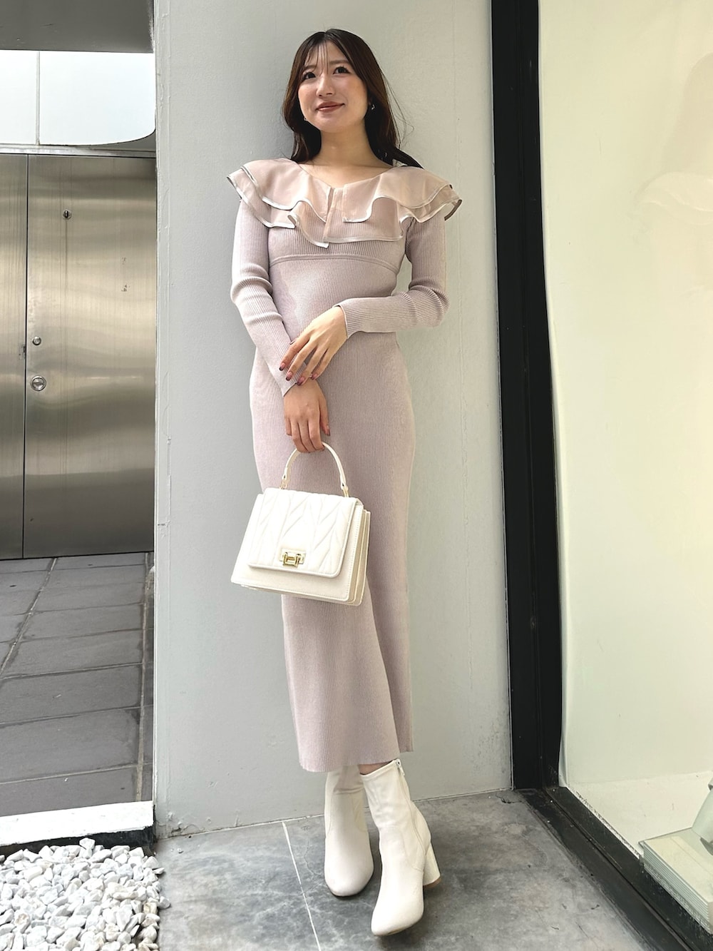 ピンク系のワンピース、ホワイト系のショルダーバッグ、ホワイト系のダウンジャケット/コートを着用したレディースの冬コーディネートの3枚目の写真