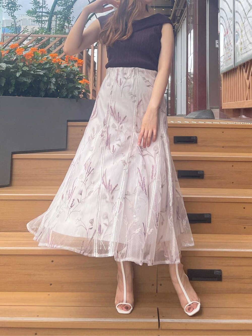 ホワイト系のその他シューズ、ホワイト系のスカート、ブラウン系のニット/セーターを着用したレディースの夏コーディネートの2枚目の写真