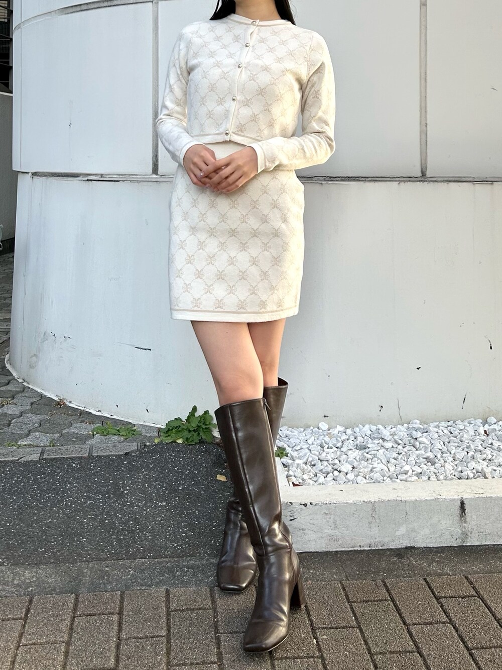 ホワイト系のワンピース、ホワイト系のダウンジャケット/コート、ブラウン系のブーツを着用したレディースの冬コーディネートの6枚目の写真