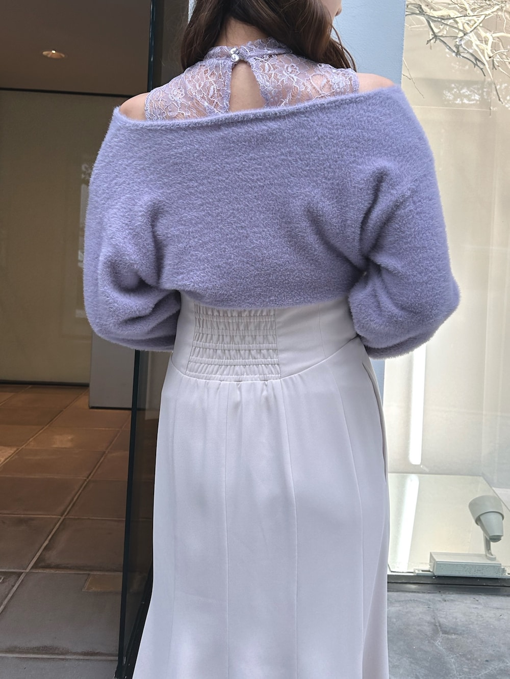 パープル系のニット/セーター、ホワイト系のスカート、ブラック系のショルダーバッグを着用したレディースの冬コーディネートの4枚目の写真