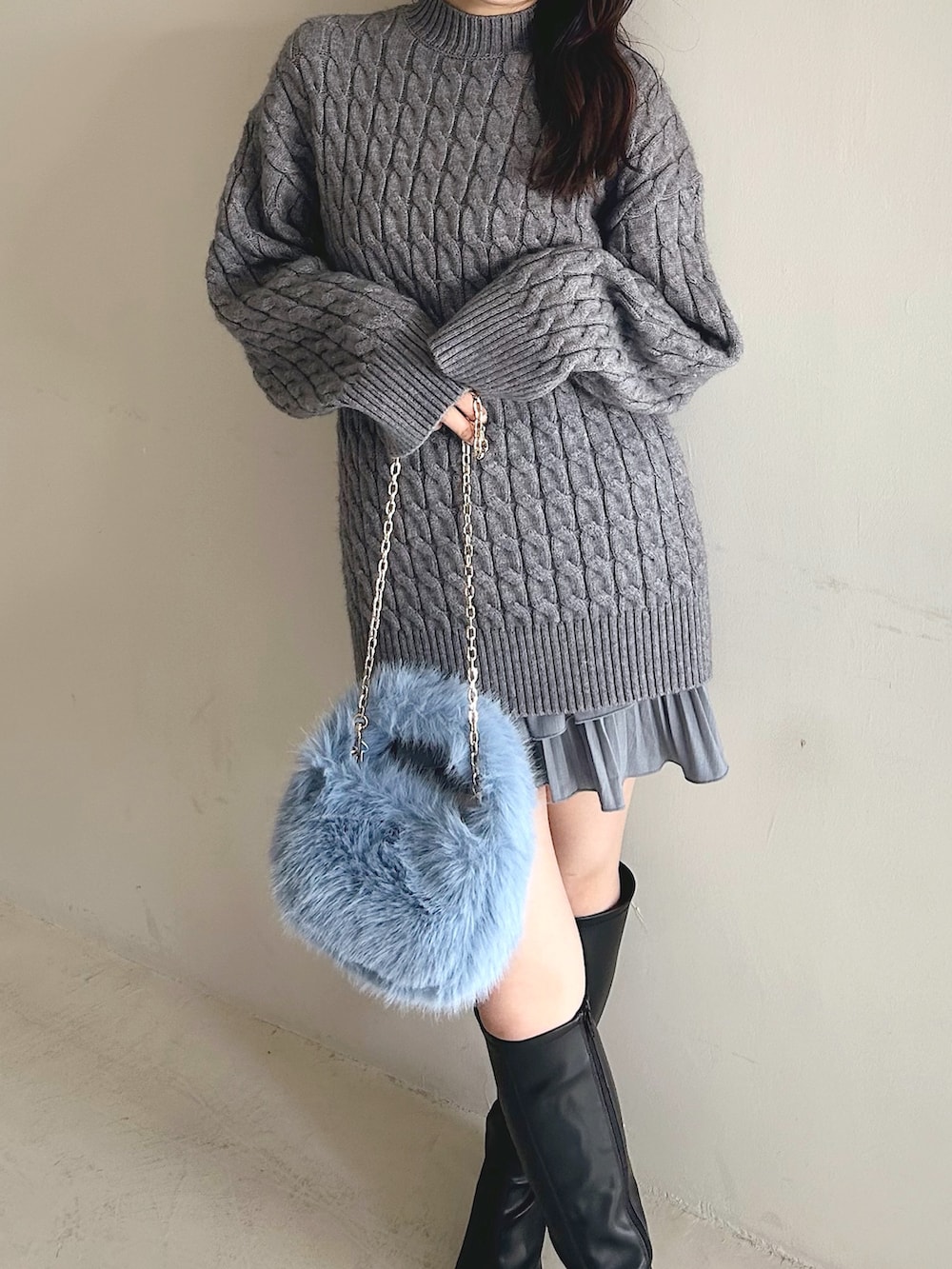 グレー系のニット/セーター、ブルー系のハンドバッグ、ブラック系のブーツを着用したレディースの冬コーディネートの4枚目の写真