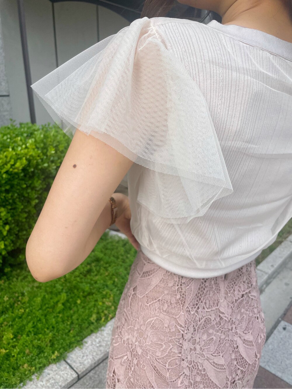 ベージュ系のスカート、ホワイト系のニット/セーターを着用したレディースの春コーディネートの4枚目の写真