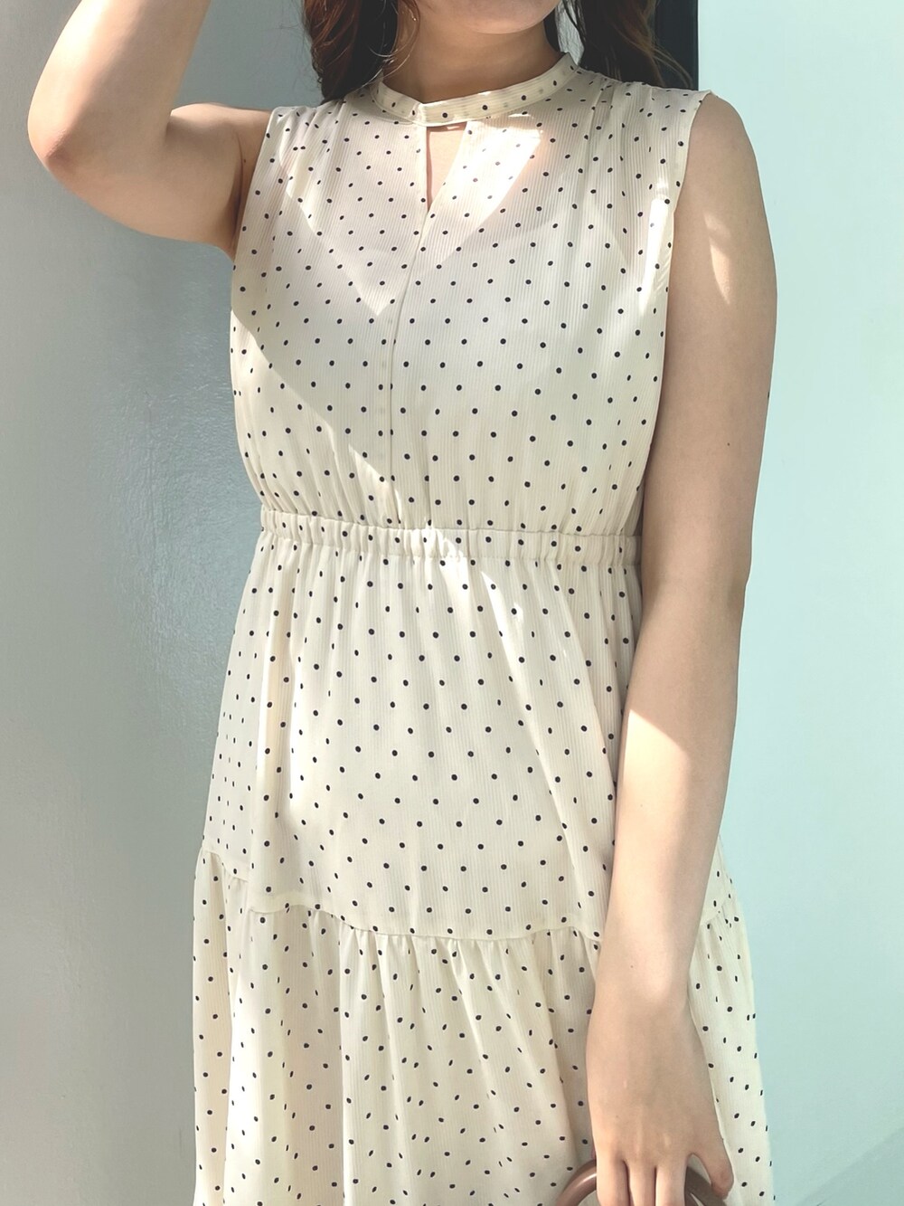 ベージュ系のワンピース、ブラウン系のトートバッグ、ホワイト系のサンダルを着用したレディースの夏コーディネートの6枚目の写真