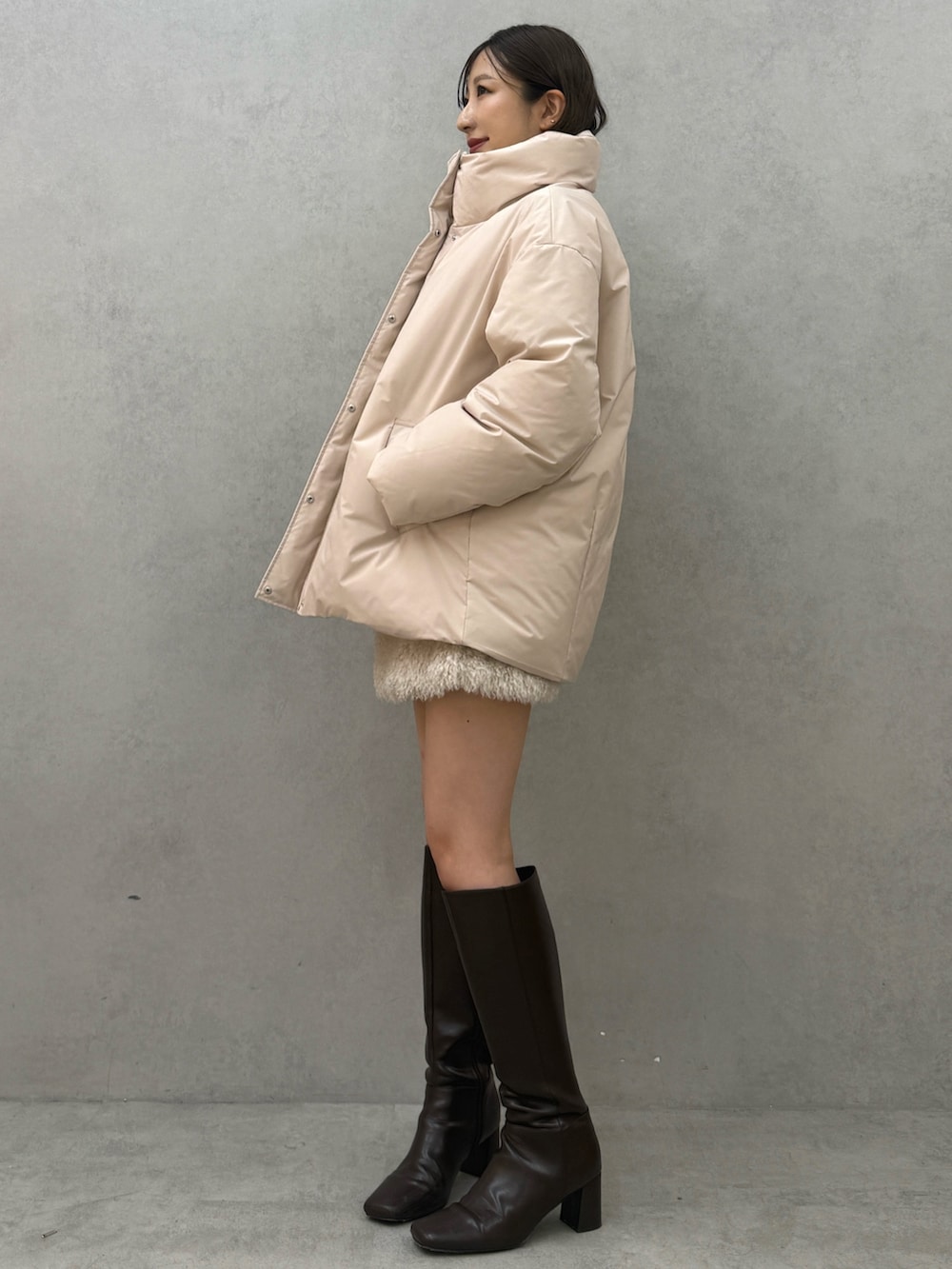 ピンク系のダウンジャケット/コート、ホワイト系のスカート、ブラウン系のブーツを着用したレディースの秋コーディネートの3枚目の写真