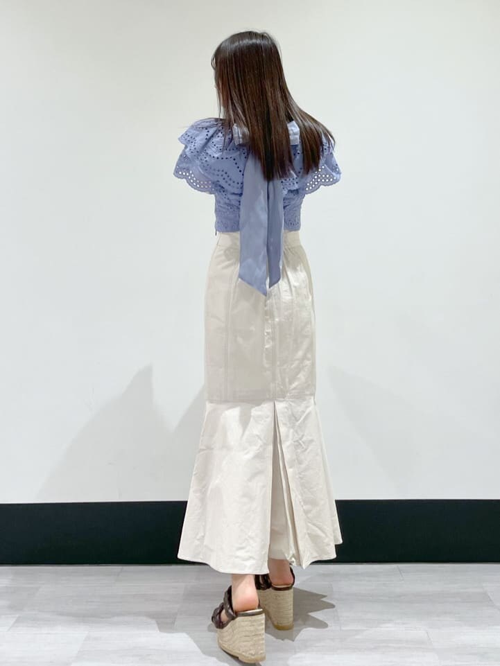 ブルー系のシャツ/ブラウス、ホワイト系のスカート、ブラウン系のサンダルを着用したレディースの冬コーディネートの2枚目の写真