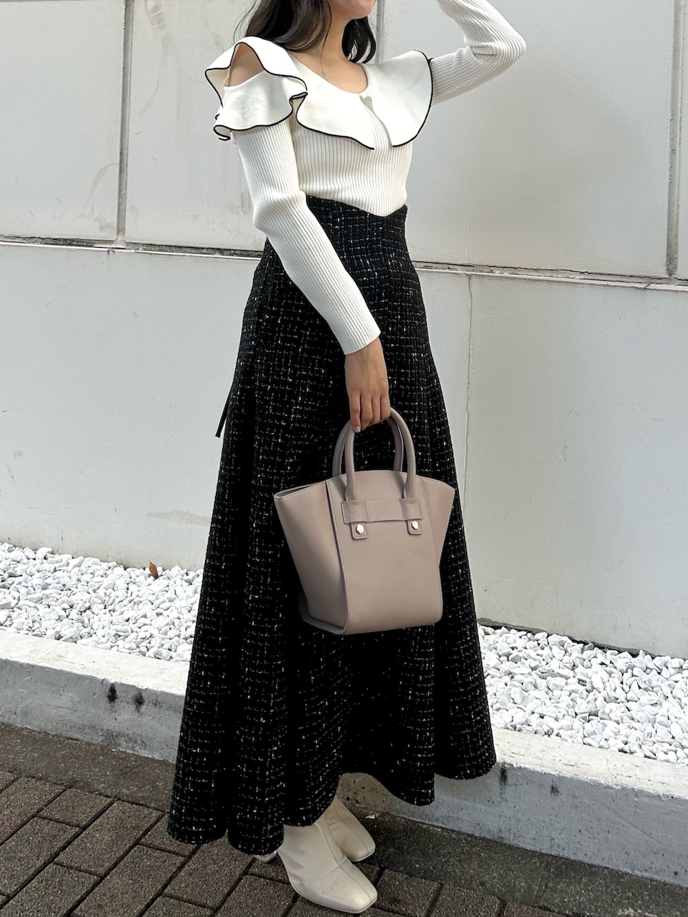 その他のニット/セーター、ベージュ系のハンドバッグ、ブラック系のスカートを着用したレディースの秋コーディネートの2枚目の写真