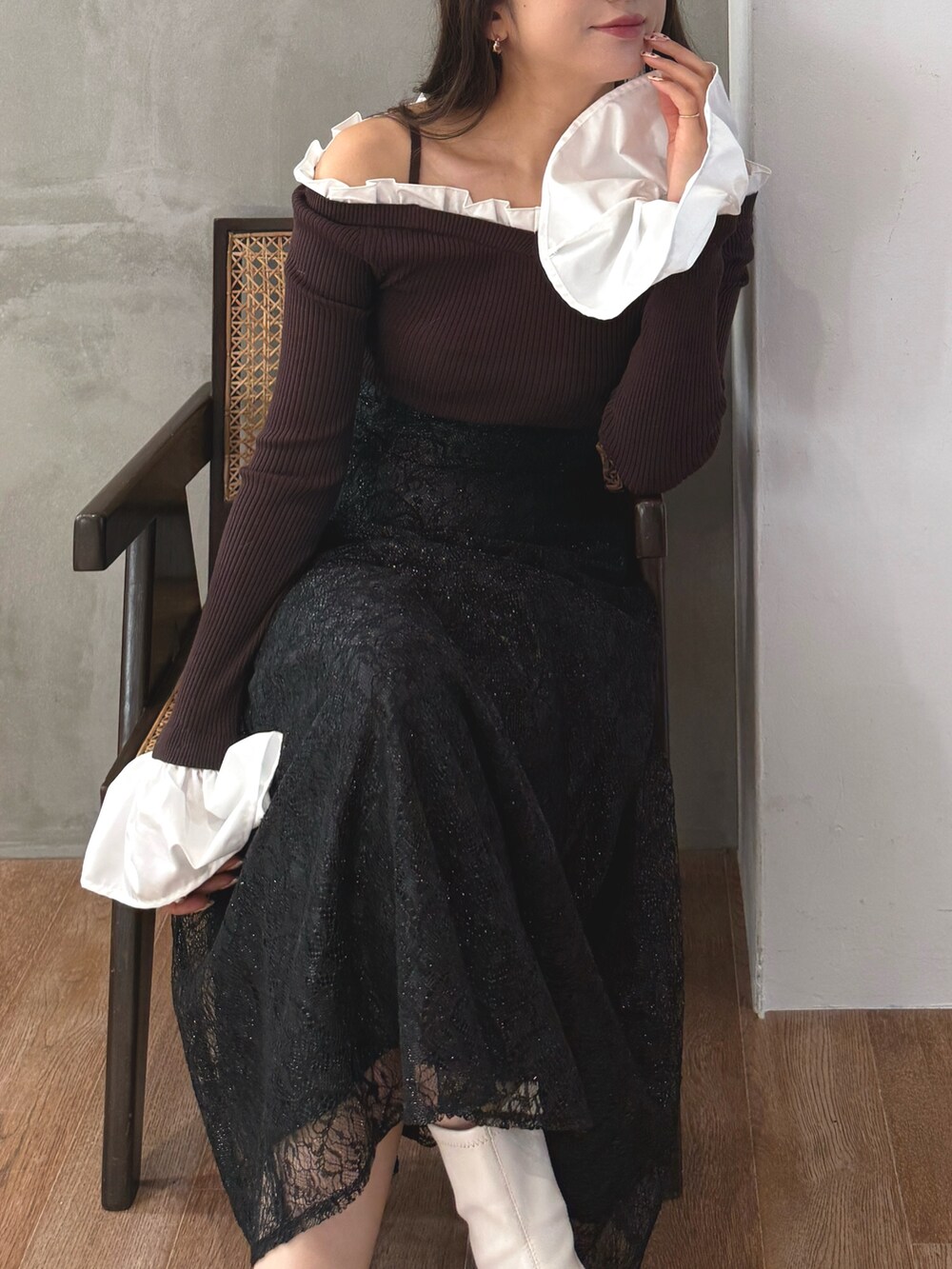 ブラウン系のニット/セーター、ブラック系のスカート、ホワイト系のブーツを着用したレディースの秋コーディネートの5枚目の写真