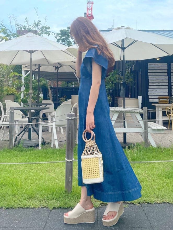 ホワイト系のハンドバッグ、ホワイト系のサンダル、ブルー系のワンピースを着用したレディースの夏コーディネートの2枚目の写真