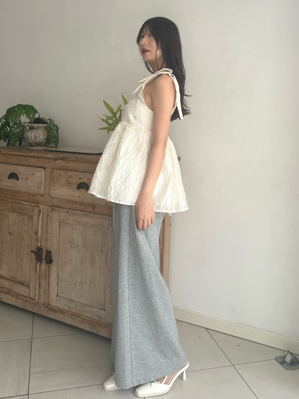 グレー系のその他パンツ、ホワイト系のシャツ/ブラウス、ホワイト系のパンプスを着用したレディースの夏コーディネートの4枚目の写真