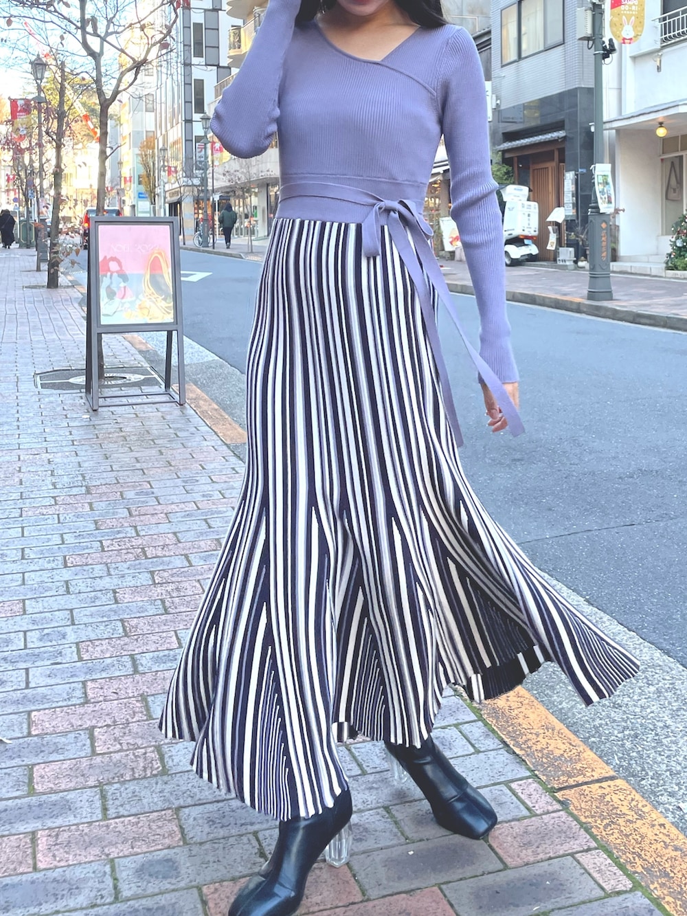 パープル系のワンピース、ホワイト系のライダースジャケットを着用したレディースの冬コーディネートの3枚目の写真