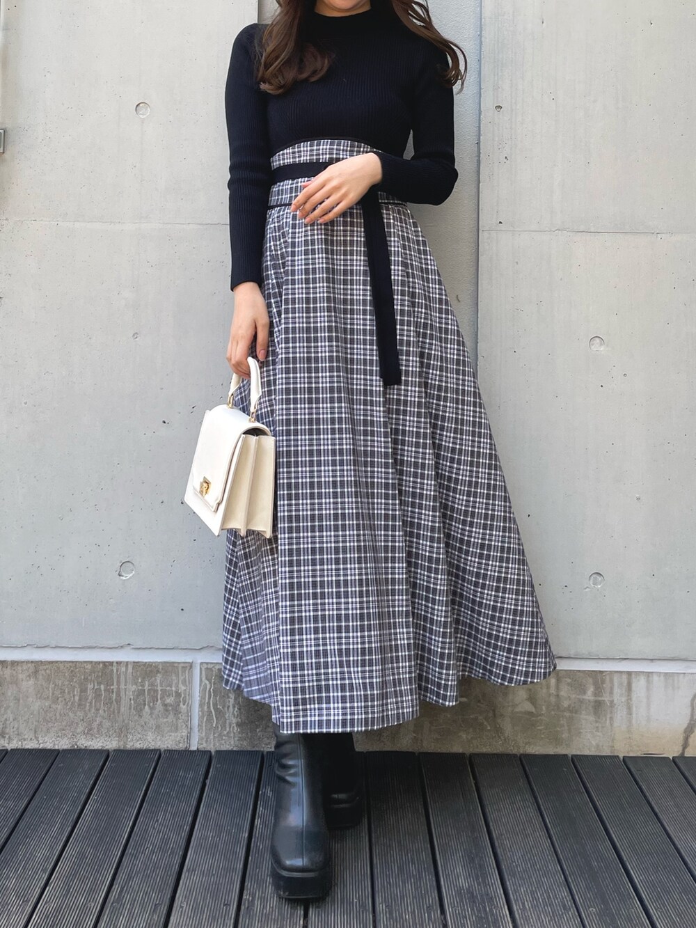 ブラック系のブーツ、ブラック系のワンピース、ブラック系のダウンジャケット/コートを着用したレディースの冬コーディネートの5枚目の写真