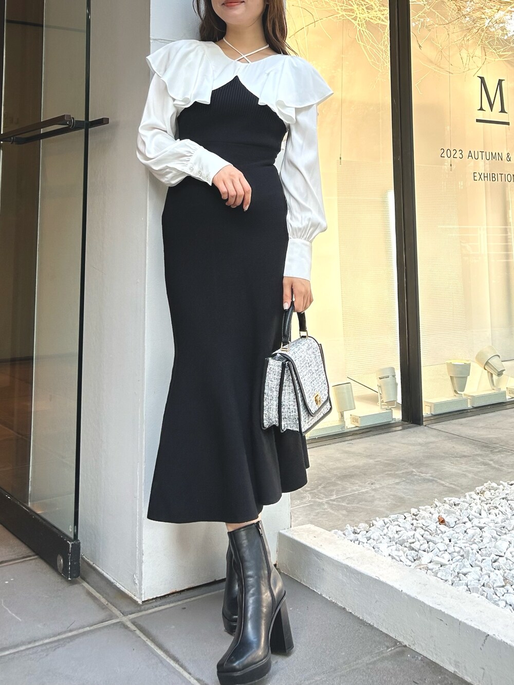 ブラック系のワンピース、ブラック系のショルダーバッグ、ブラック系のブーツを着用したレディースの秋コーディネートの2枚目の写真