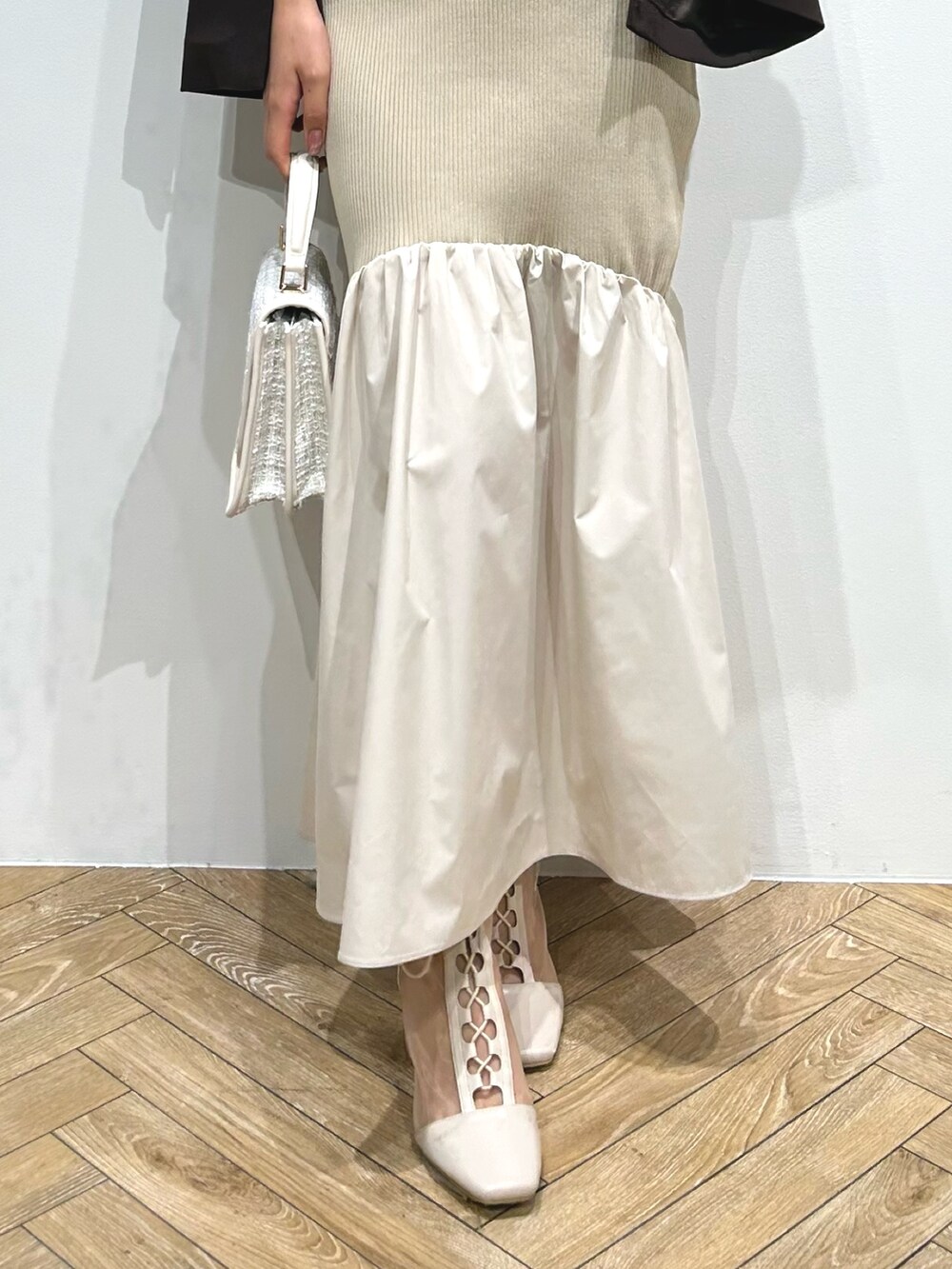 ブラウン系のテーラードジャケット、ベージュ系のワンピース、ホワイト系のブーツを着用したレディースの夏コーディネートの10枚目の写真