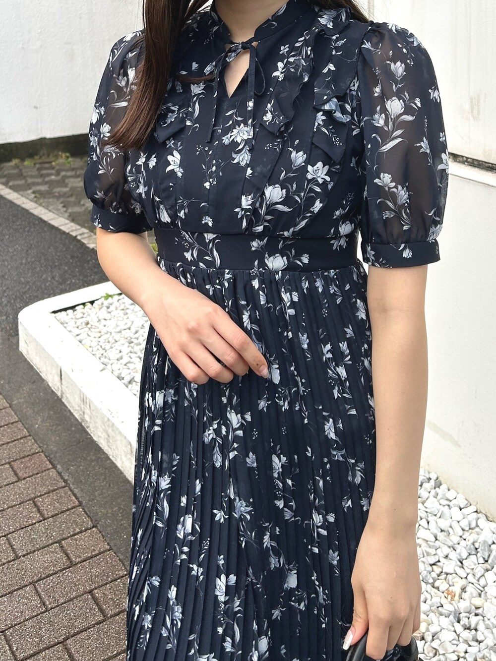 ブルー系のワンピース、ブラック系のブーツ、ブラック系のハンドバッグを着用したレディースの春コーディネートの5枚目の写真