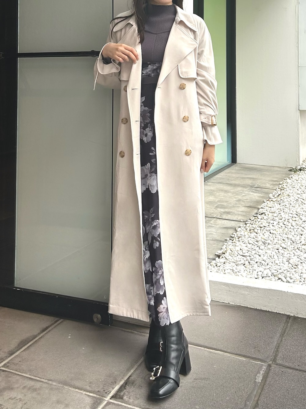 ホワイト系のトレンチコート、パープル系のワンピース、ブラック系のブーツを着用したレディースの冬コーディネートの3枚目の写真