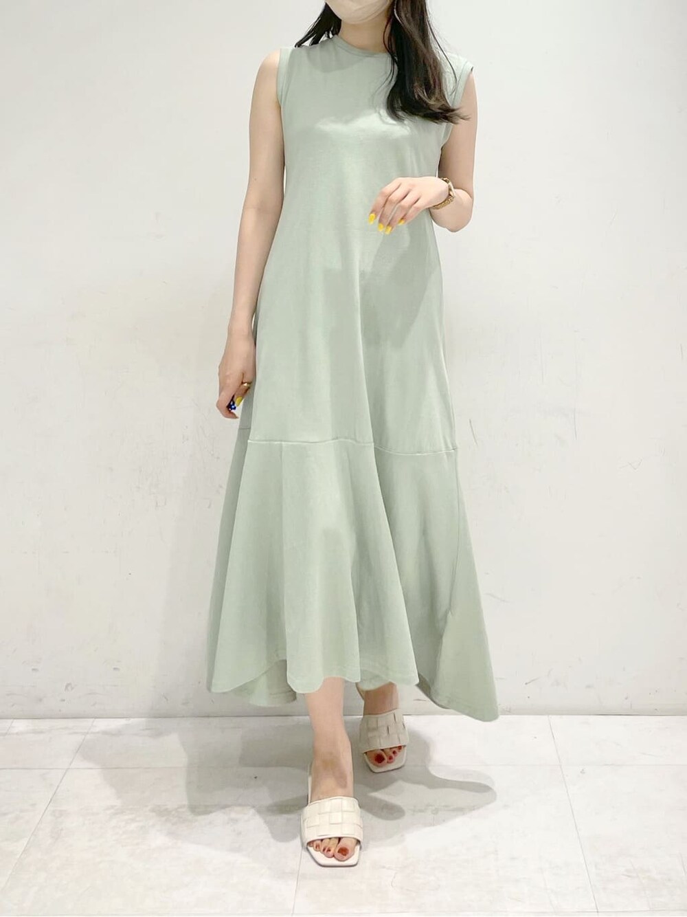 ホワイト系のサンダル、グリーン系のワンピースを着用したレディースの夏コーディネートの2枚目の写真