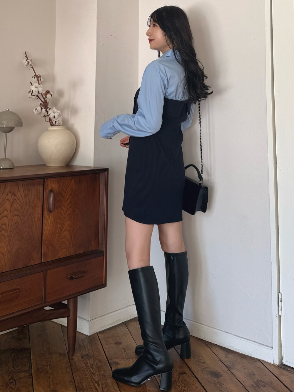 ブルー系のワンピース、ブラック系のブーツを着用したレディースの秋コーディネートの2枚目の写真