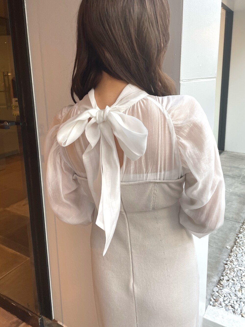 ホワイト系のワンピース、ベージュ系のライダースジャケットを着用したレディースの冬コーディネートの7枚目の写真