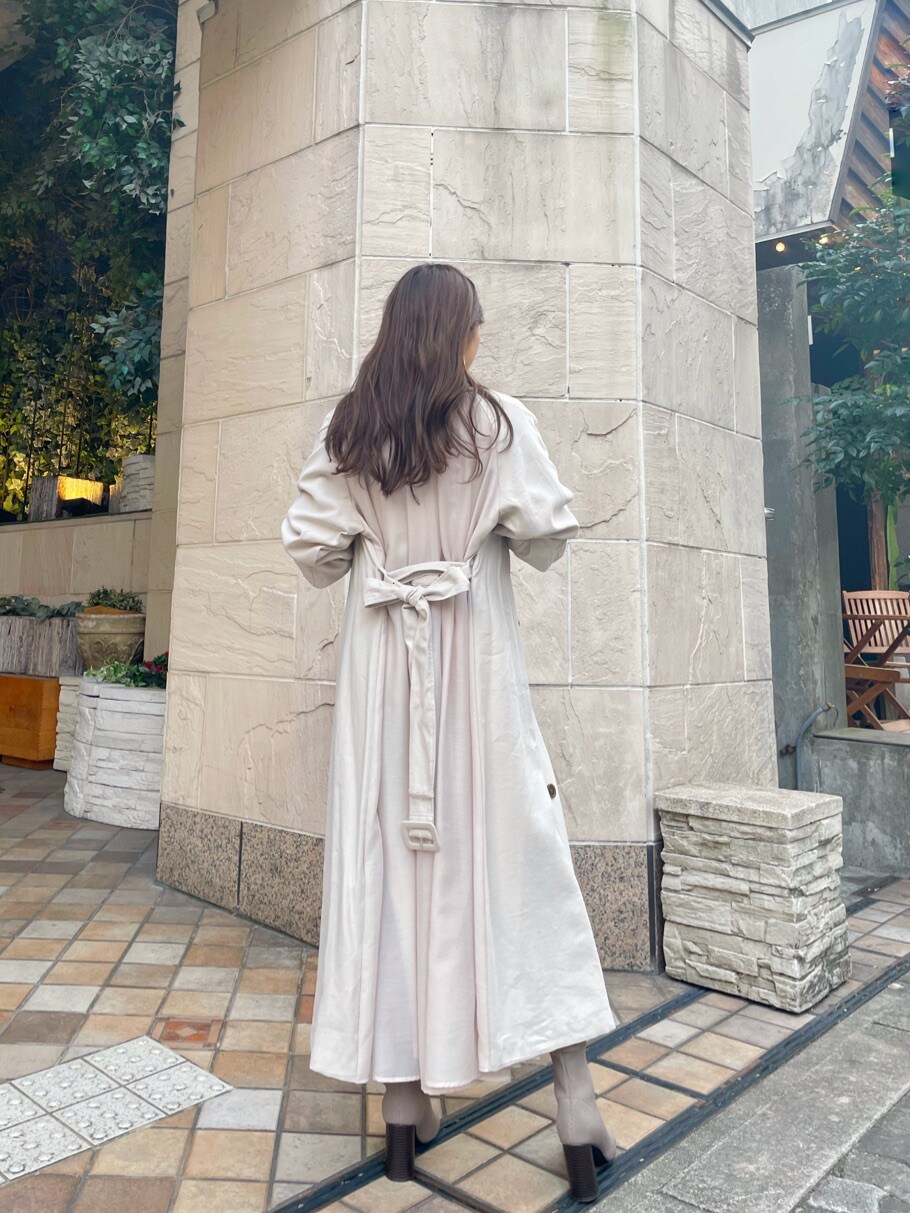 ベージュ系のトレンチコート、ブラウン系のスカートを着用したレディースの冬コーディネートの2枚目の写真