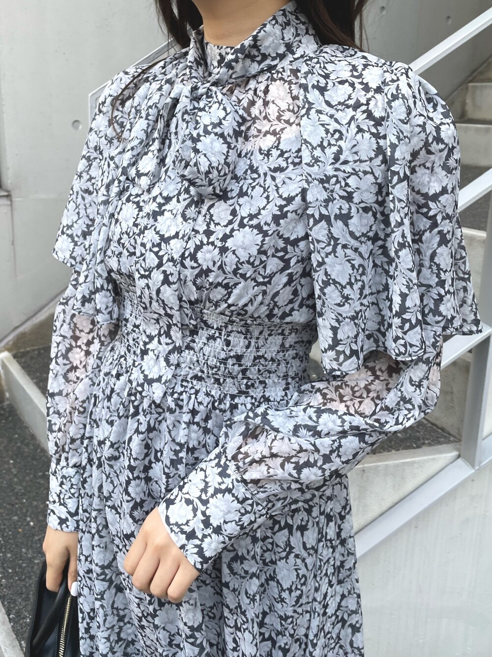 ブラック系のワンピース、ブラック系のハンドバッグ、ブラック系のブーツを着用したレディースの冬コーディネートの5枚目の写真