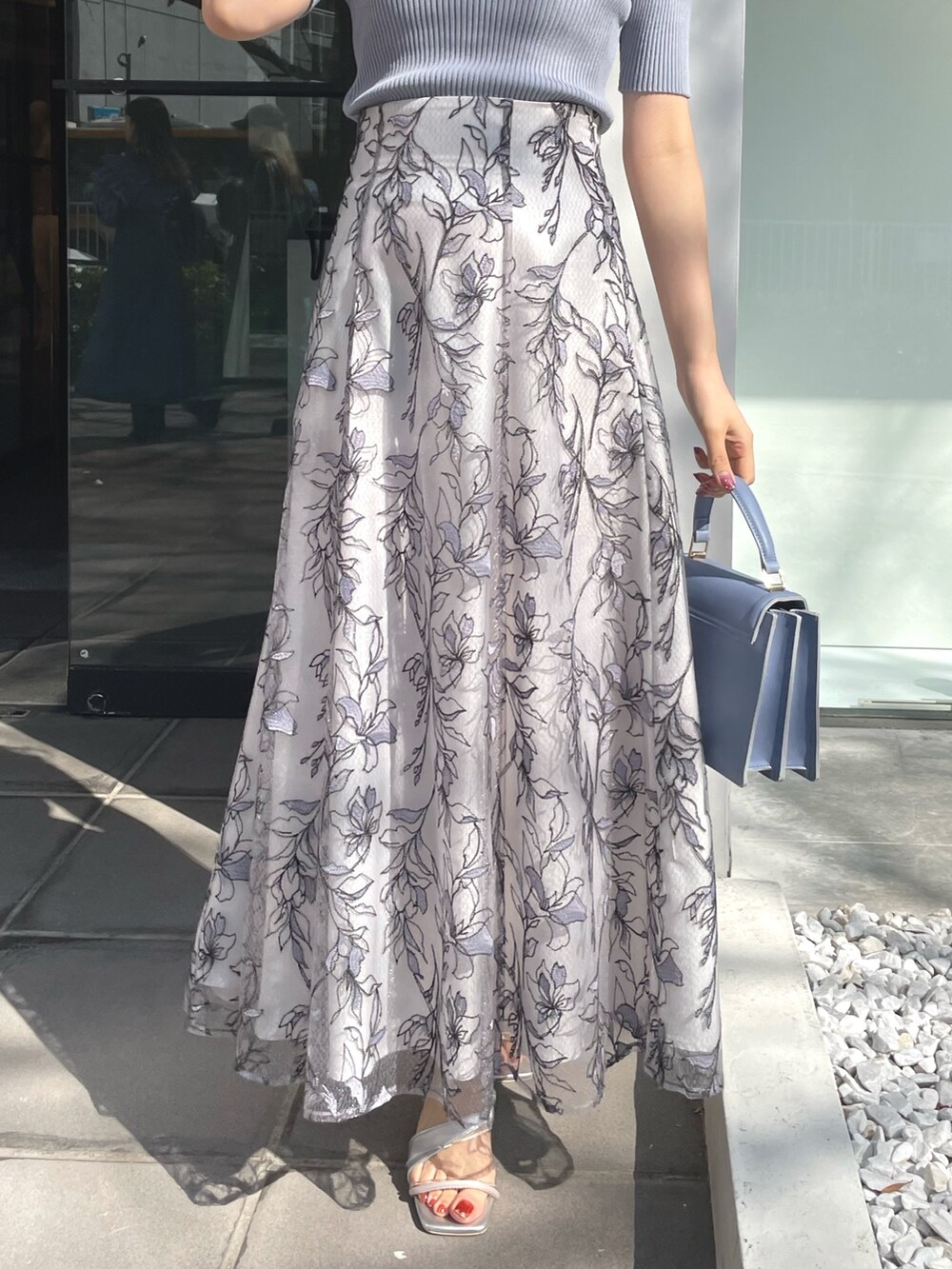 シルバー系のサンダル、ブルー系のハンドバッグ、ブルー系のニット/セーターを着用したレディースの春コーディネートの5枚目の写真